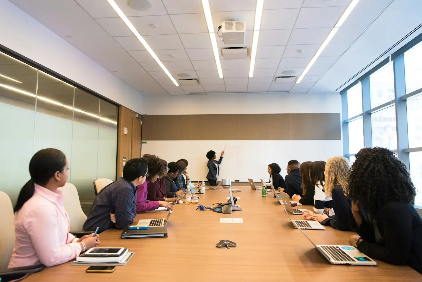 Groupe écoutant une intervenante en salle de réunion