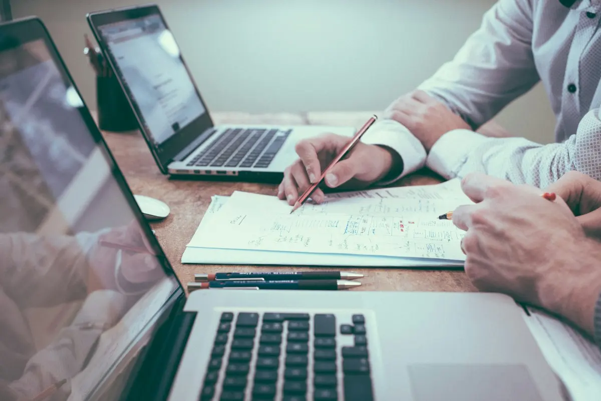 Mains prenant des notes près d’un ordinateur