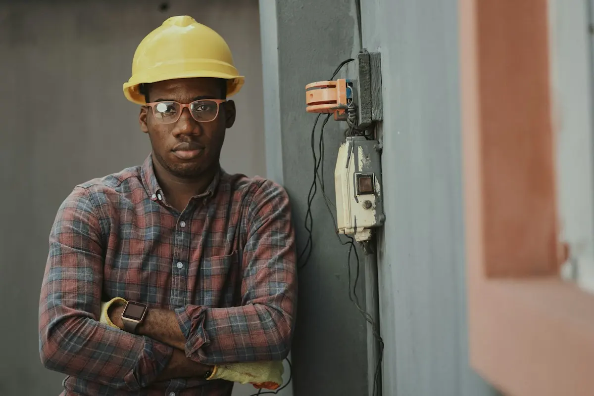Électricien en casque de chantier, bras croisés