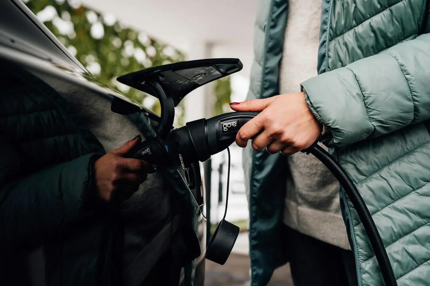 Personne branchant une voiture électrique