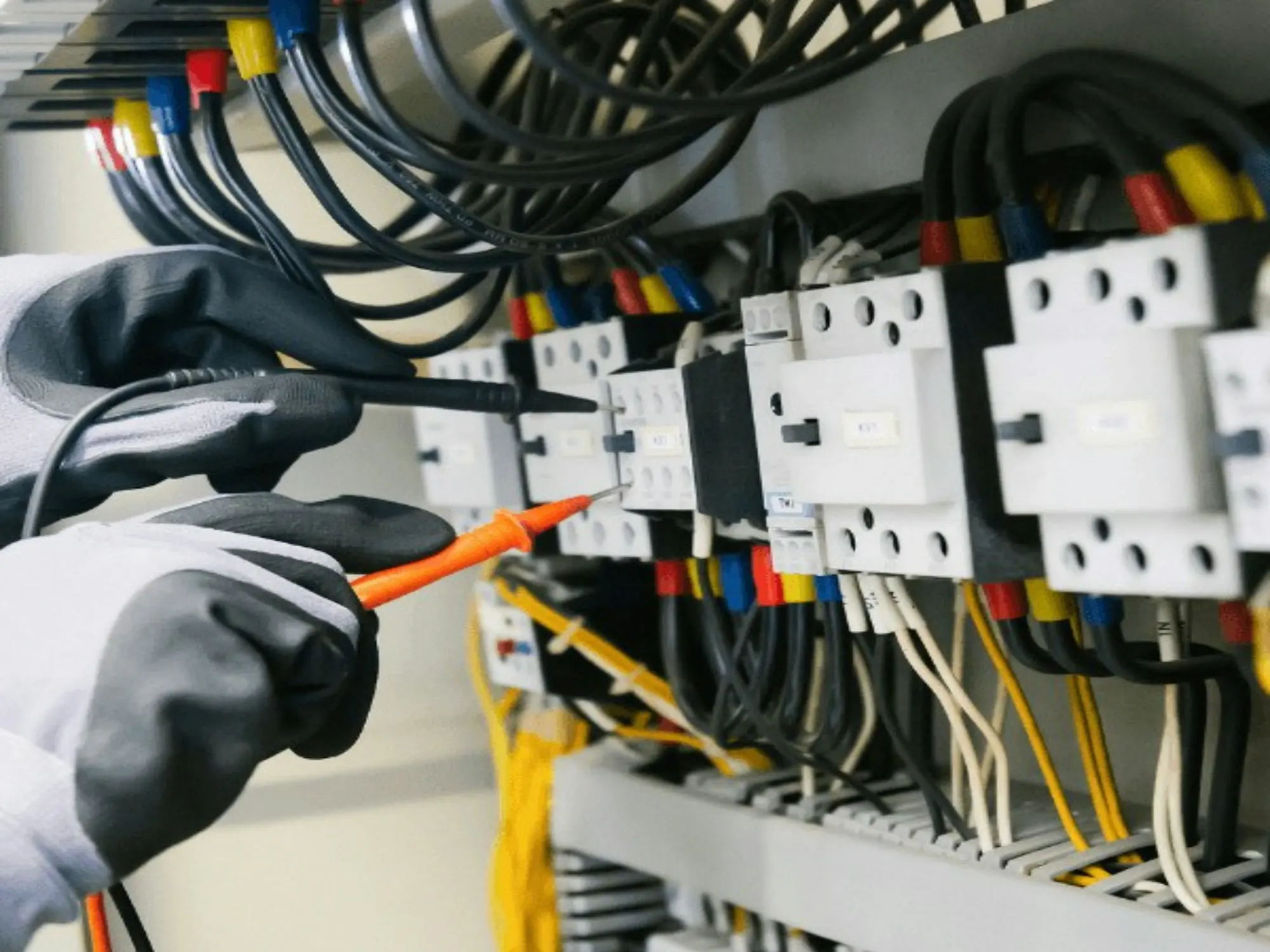 Électricien testant un tableau électrique au multimètre