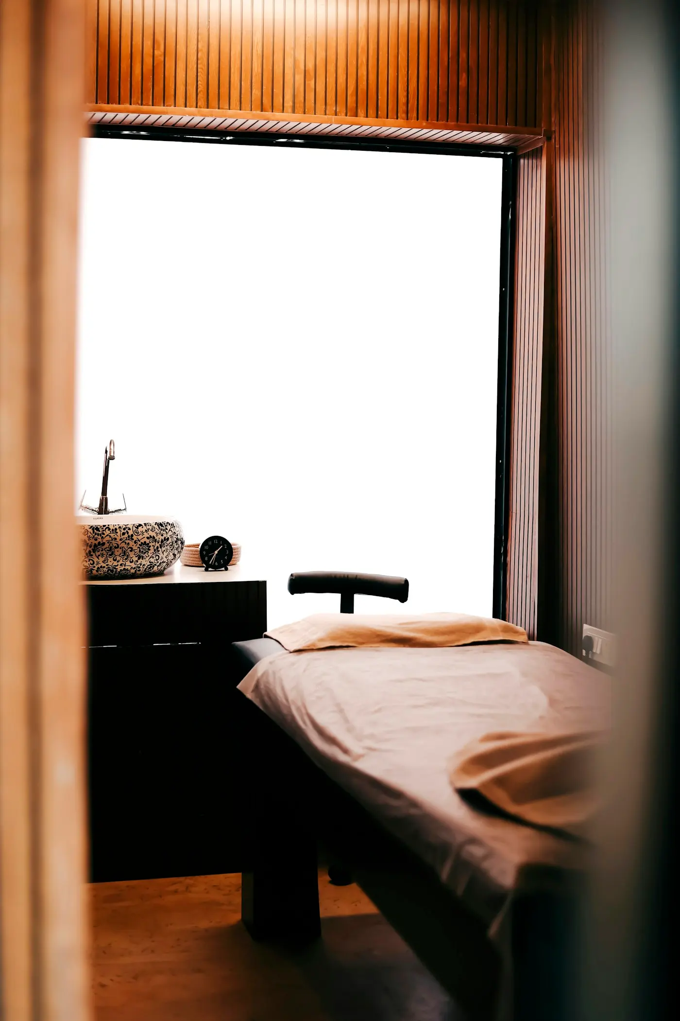 Cabine de soins avec table de massage et linge beige