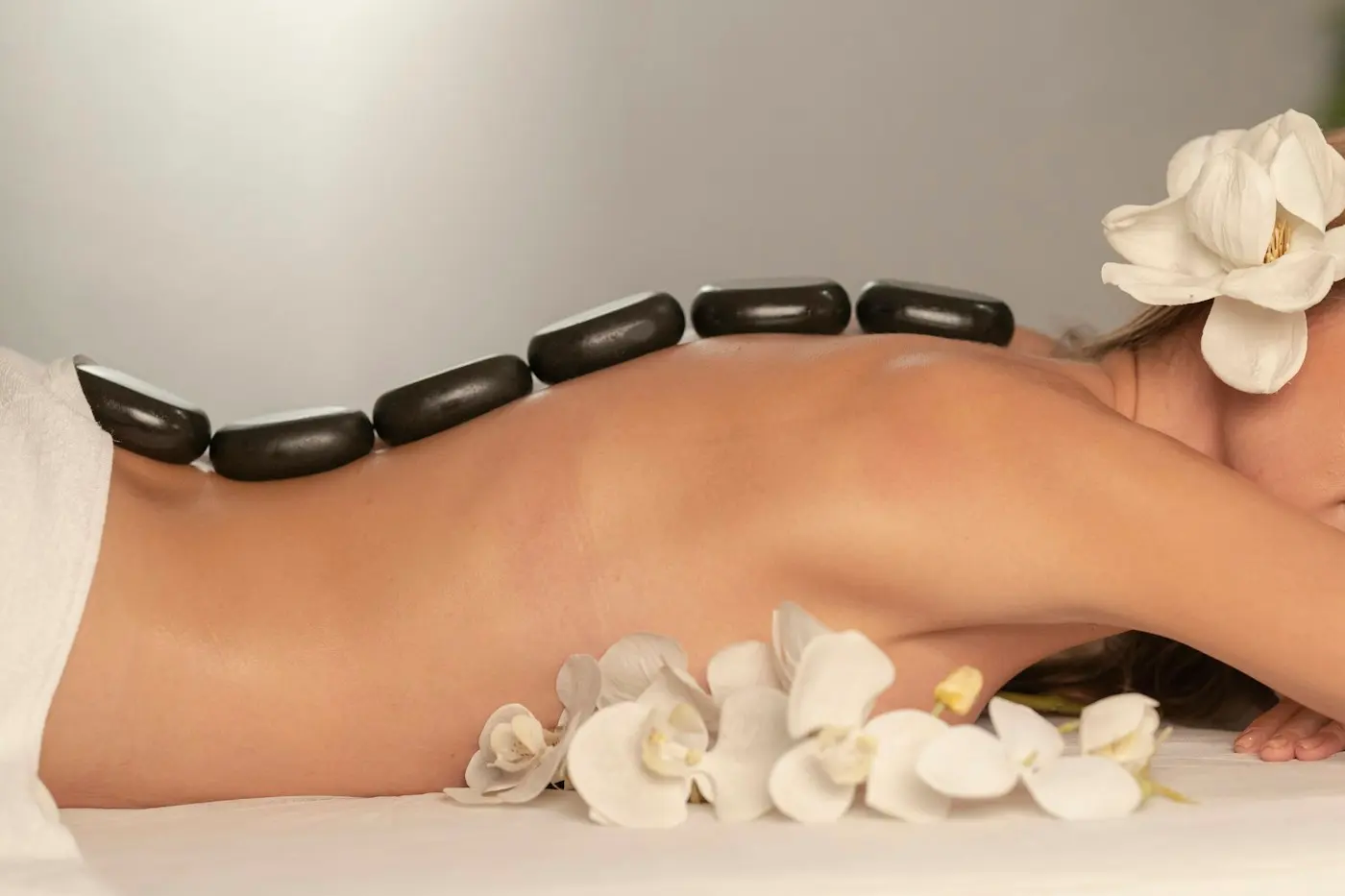 Massage aux pierres chaudes, orchidées blanches