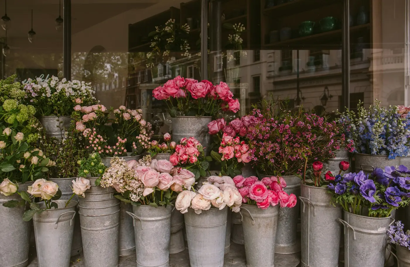 Seaux de fleurs fraîches devant la vitrine de la boutique