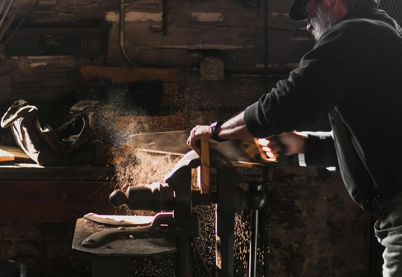 Atelier de menuiserie, sciage dans la sciure en contre-jour