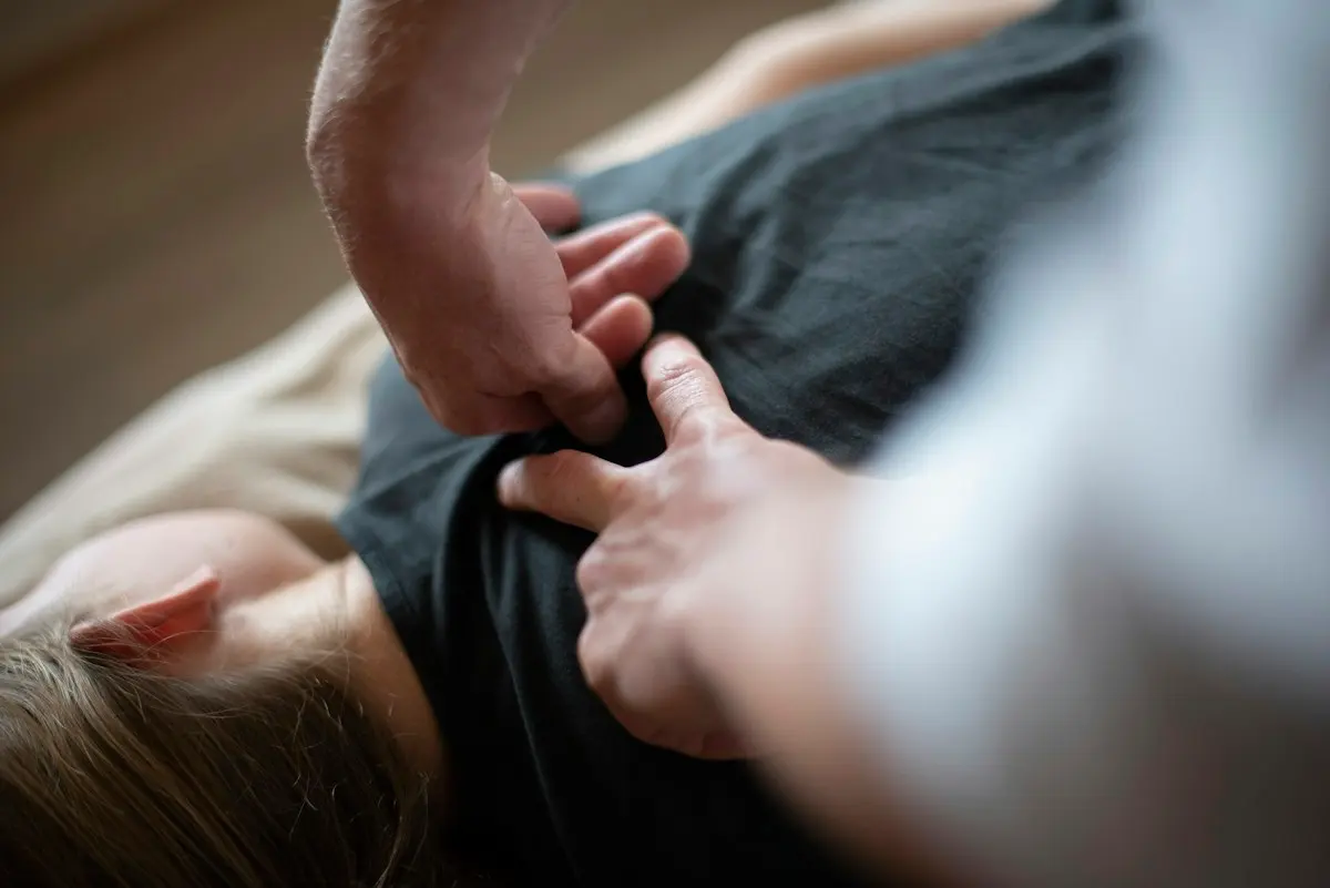Mains sur l’épaule d’un patient allongé