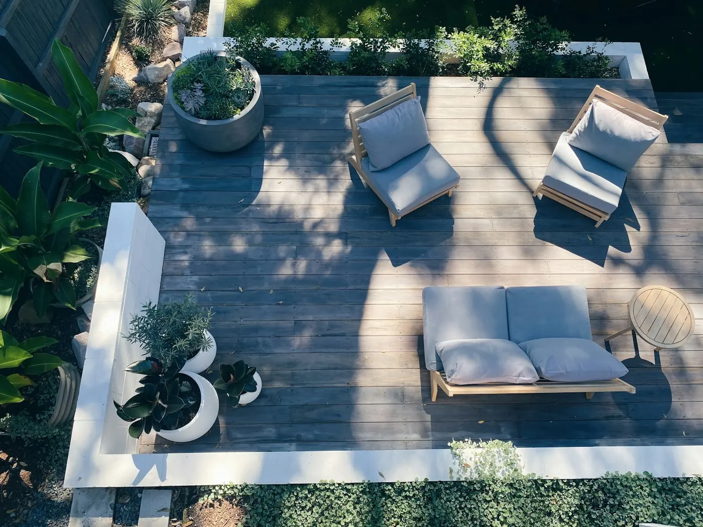 Terrasse en bois vue du dessus avec salon de jardin