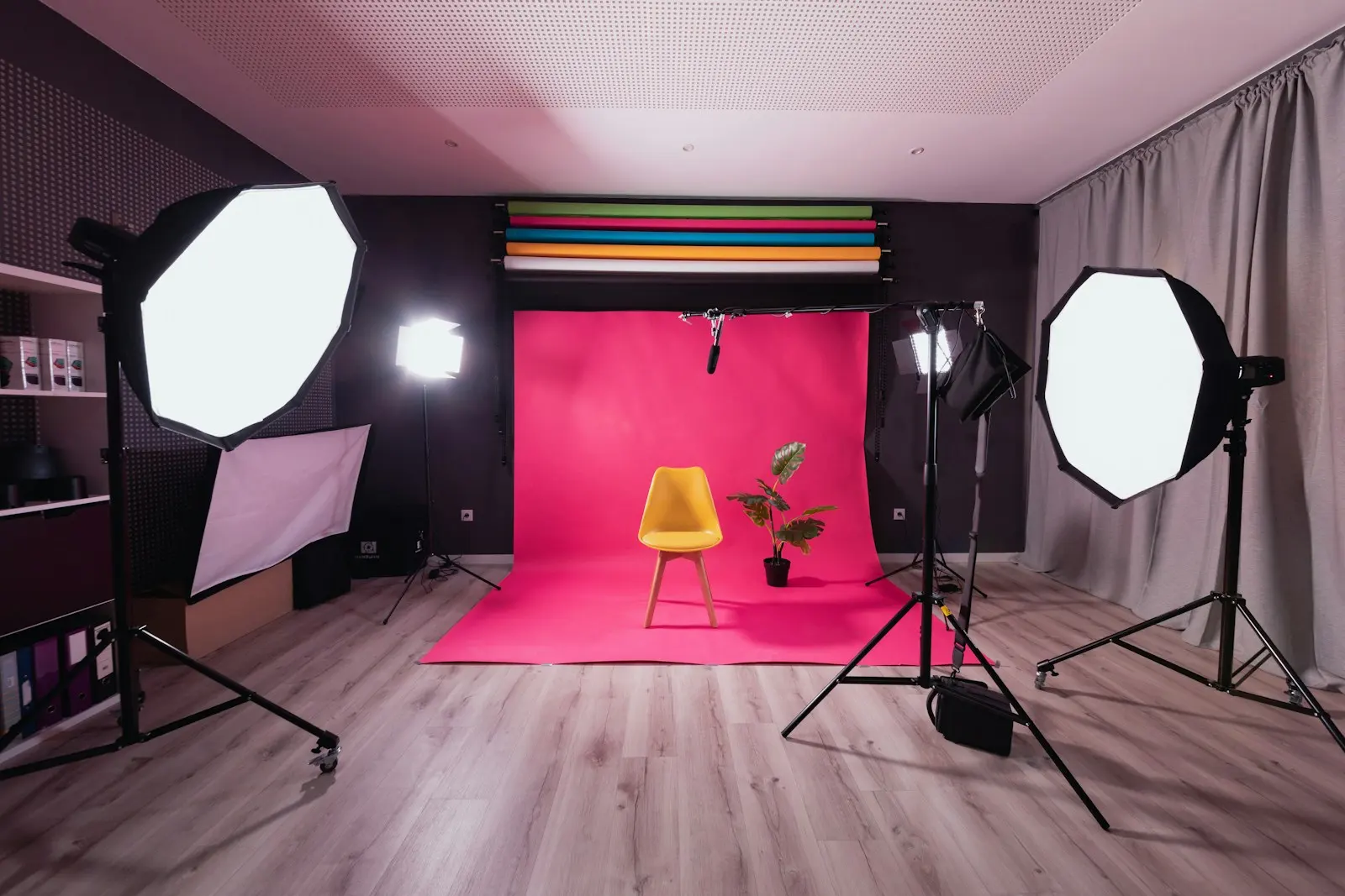 Studio photo : fond rose, chaise jaune et boîtes à lumière