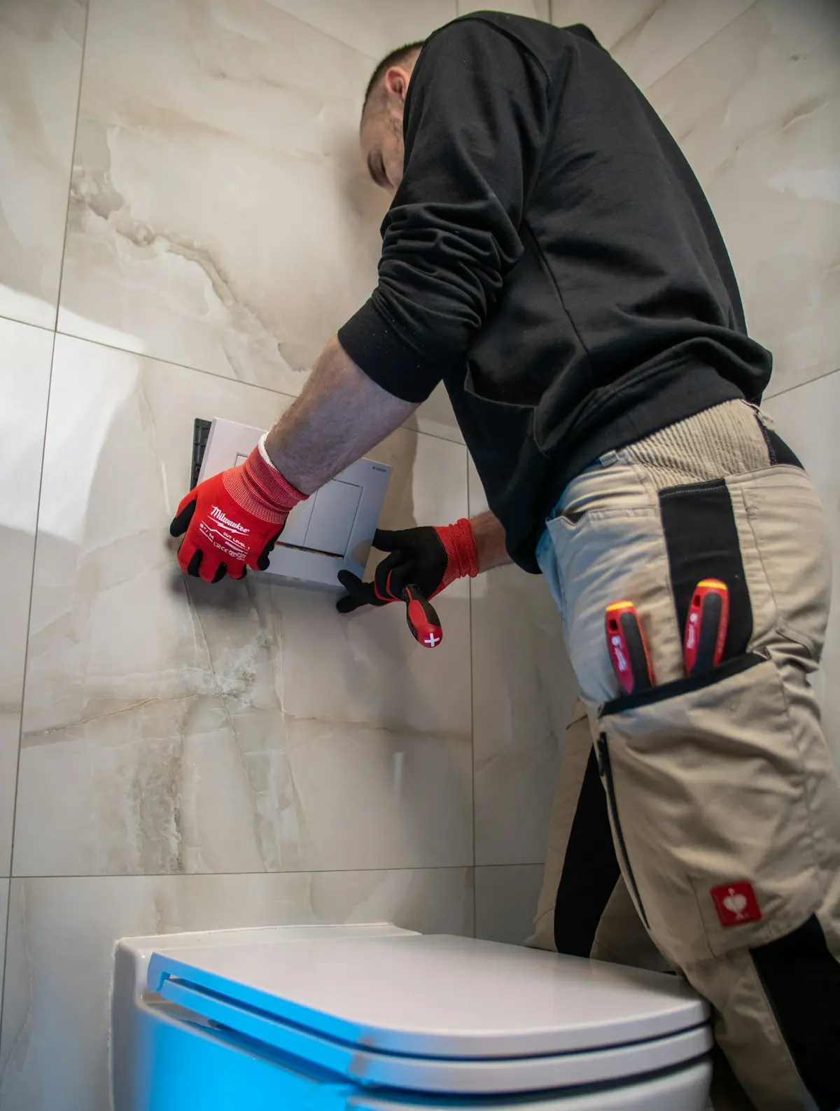 Artisan plombier posant un raccord dans une salle de bain