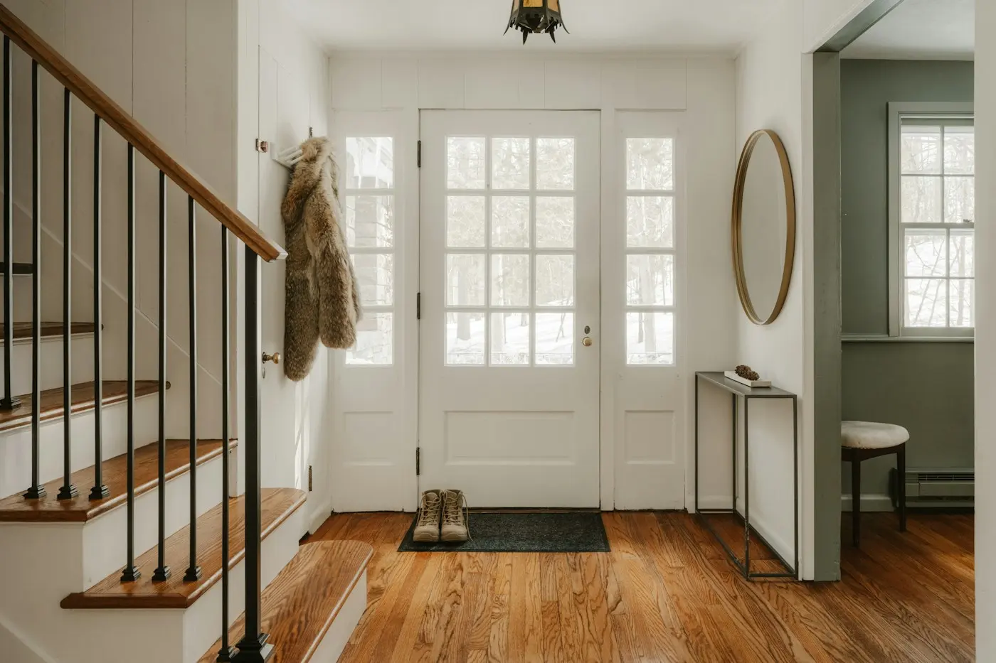 Entrée lumineuse d’une maison avec escalier en bois