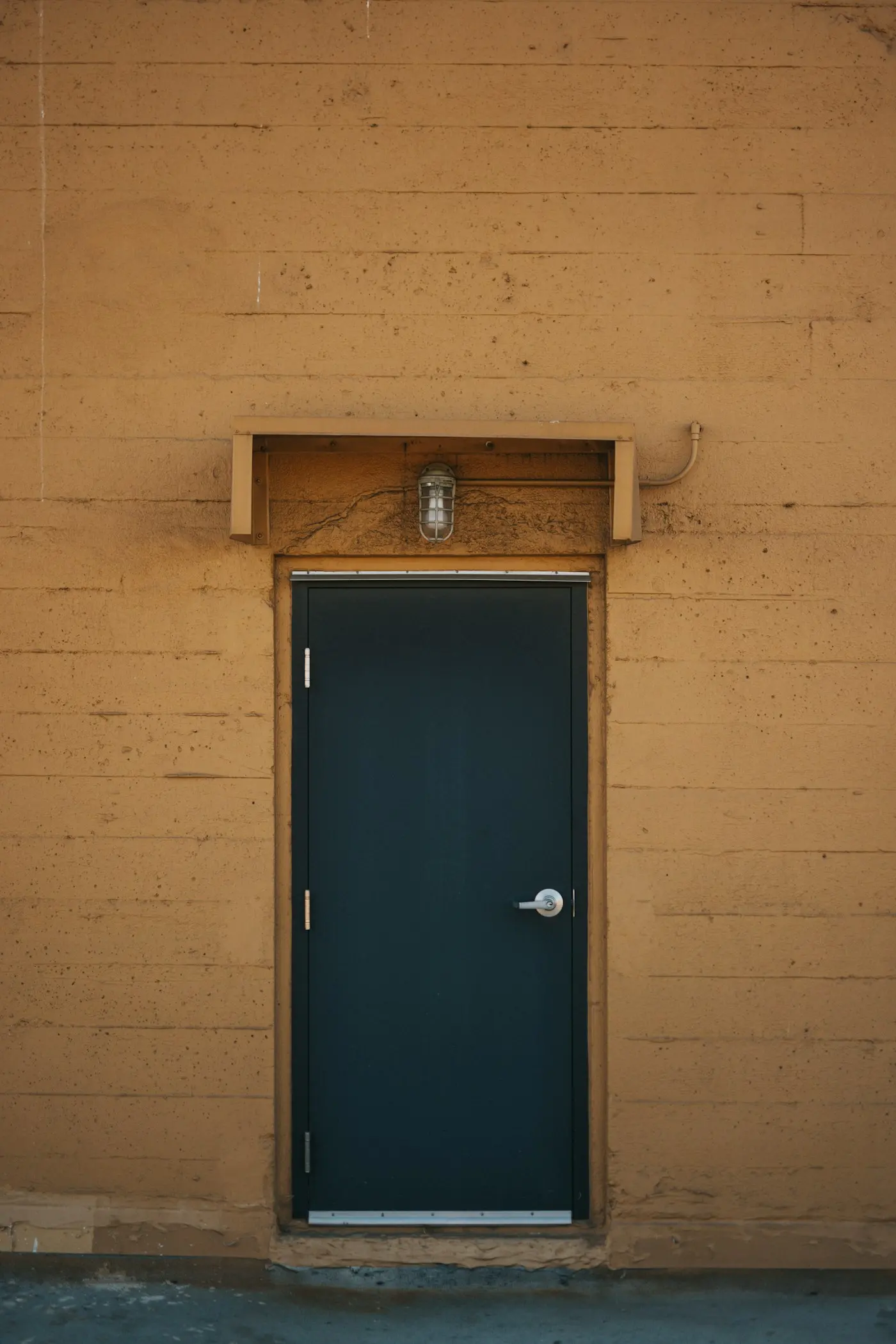 Porte d’entrée sombre dans une façade en bois