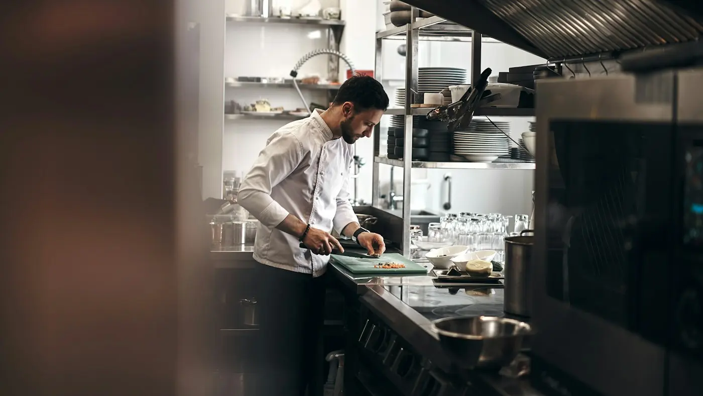 Cuisinier préparant des légumes en cuisine